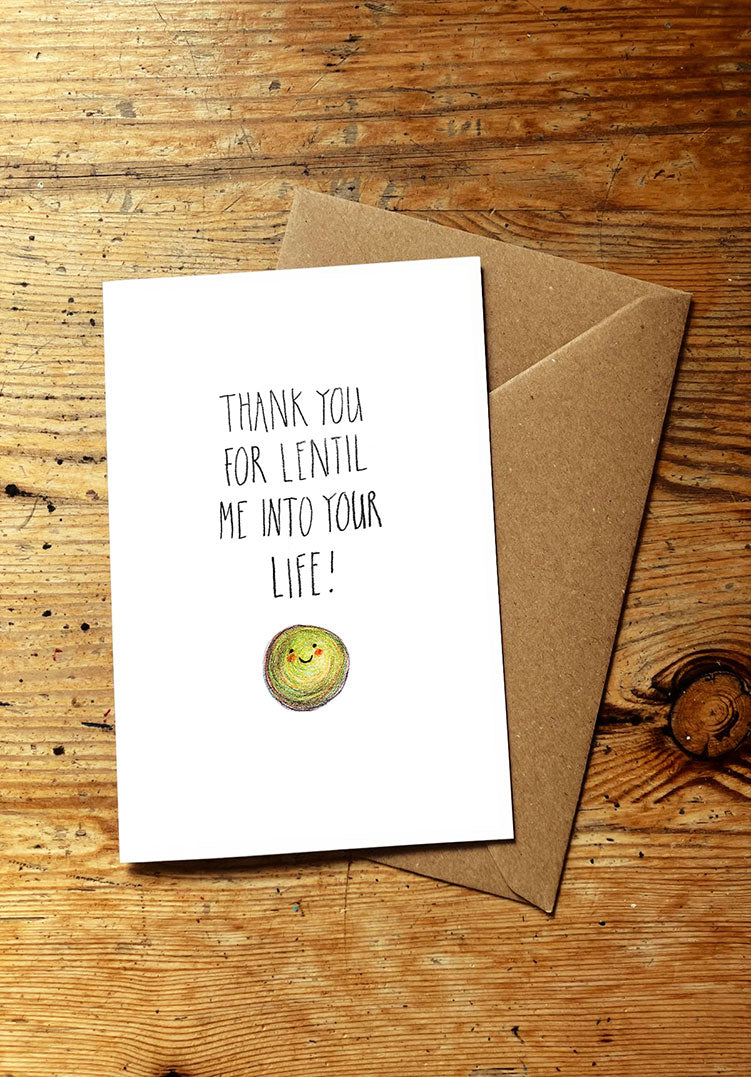 Veg pun greeting card with a smiley lentil and envelope on a wooden surface