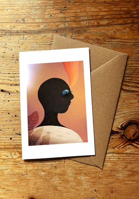 Greeting card with silhouette of a face with planets and moon and stars,  on a wooden surface