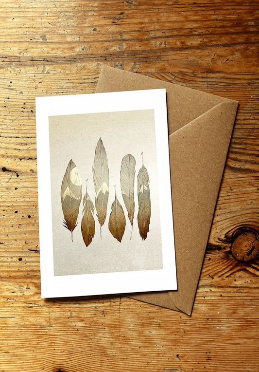 Greeting card with feather design on a wooden surface