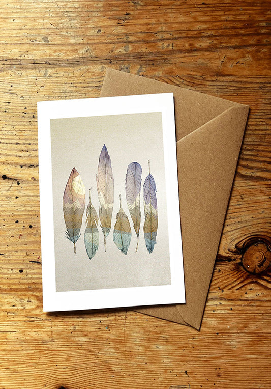 Greeting card with feather design on a wooden surface