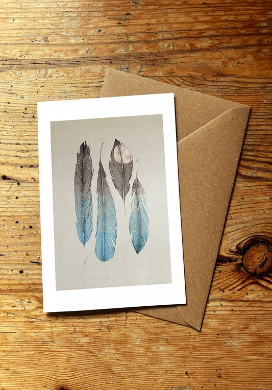 Greeting card with feather design on a wooden surface
