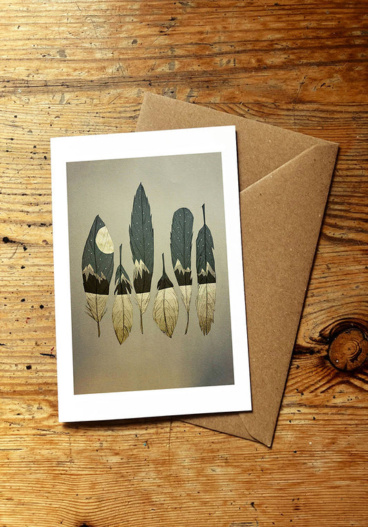 Greeting card with a nature-themed feather design on a wooden surface