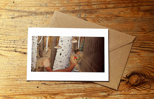 Greeting card with a nature-themed illustration of a boy walking through the woods and a fox looking at him, on a wooden surface