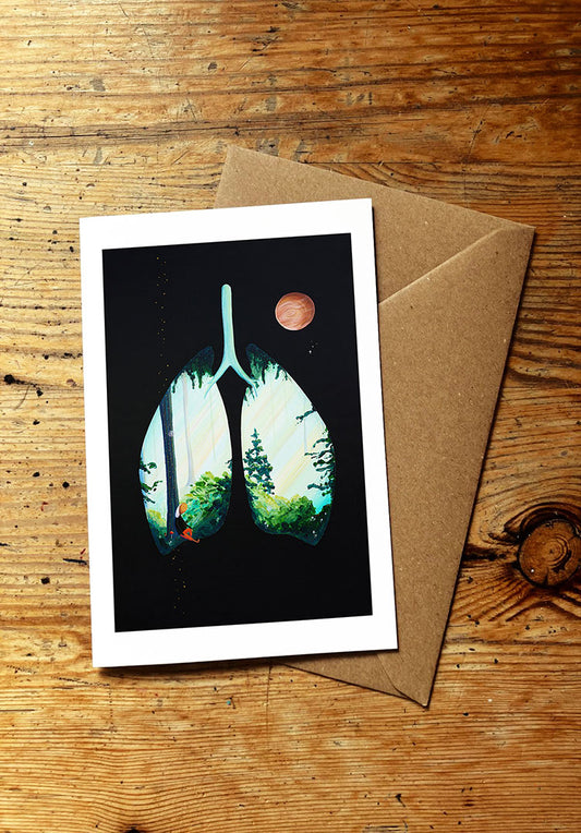 Greeting card with nature design of lungs with forest in them on a wooden surface