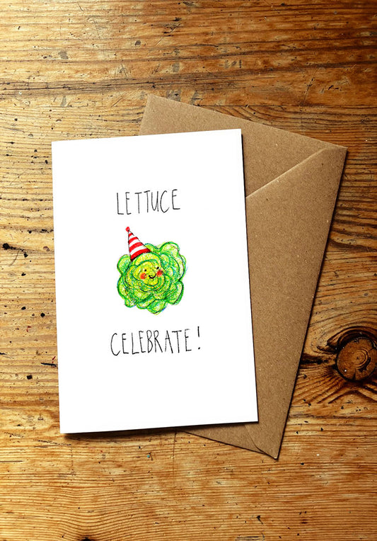 Veg pun greeting card with smiley lettuce illustration and text 'Lettuce Celebrate!' on a wooden surface