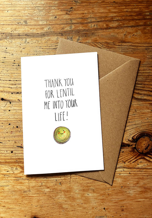 Veg pun greeting card with a smiley lentil and envelope on a wooden surface