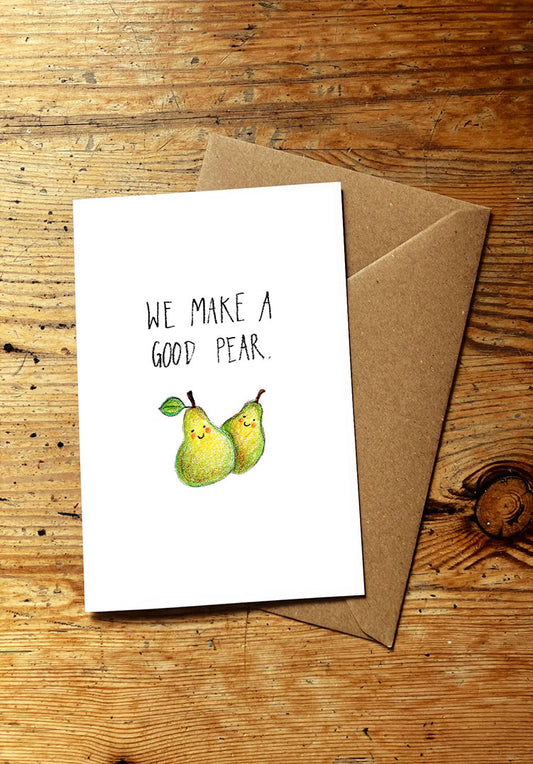 Fruit and veg pun greeting card with two smiley pears and text 'We make a good pear' on a wooden surface