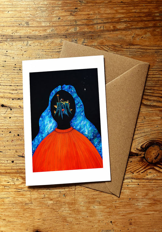 Greeting card with a blue and orange and mushroom art design on a wooden surface