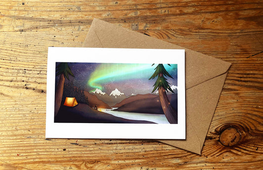 Greeting card with Northern Lights wild camping design on a wooden surface