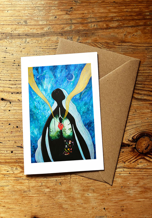Greeting card with a design of a woman with long hair and forest lungs and wild edible plants and mushrooms in her stomach under a night sky with crescent moon, on a wooden surface