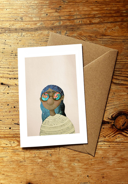 Greeting card with an illustration of a woman wearing glasses with ocean waves reflected in them, on a wooden surface.