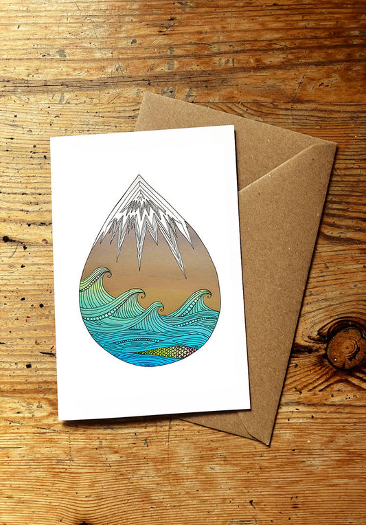 Greeting card with mountain and wave design on a wooden surface