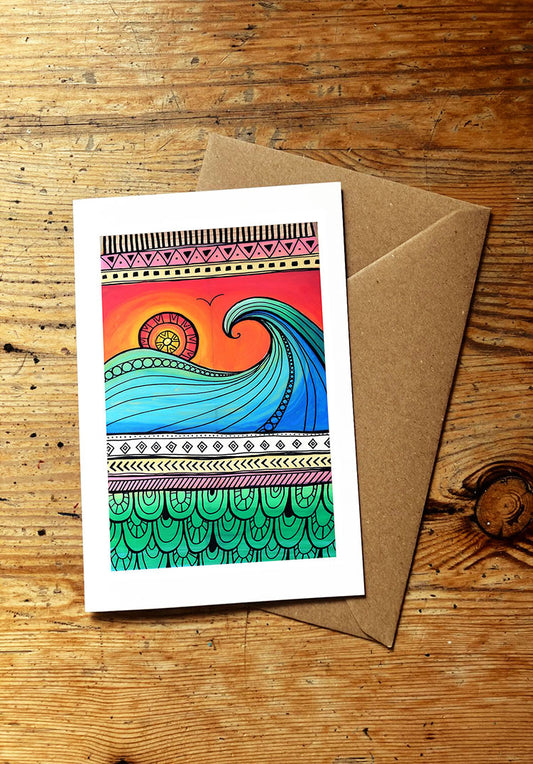 Colorful wave design card with a brown envelope on a wooden surface