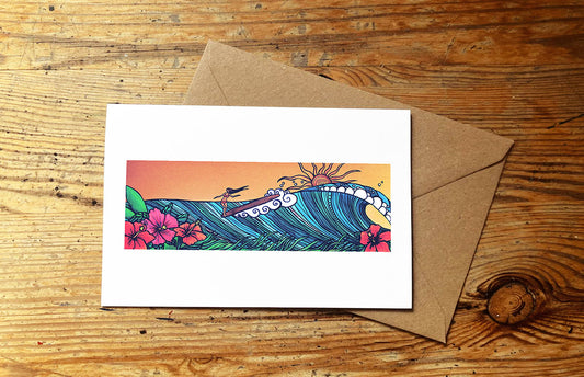 Greeting card with a colorful surf girl design and envelope on a wooden surface