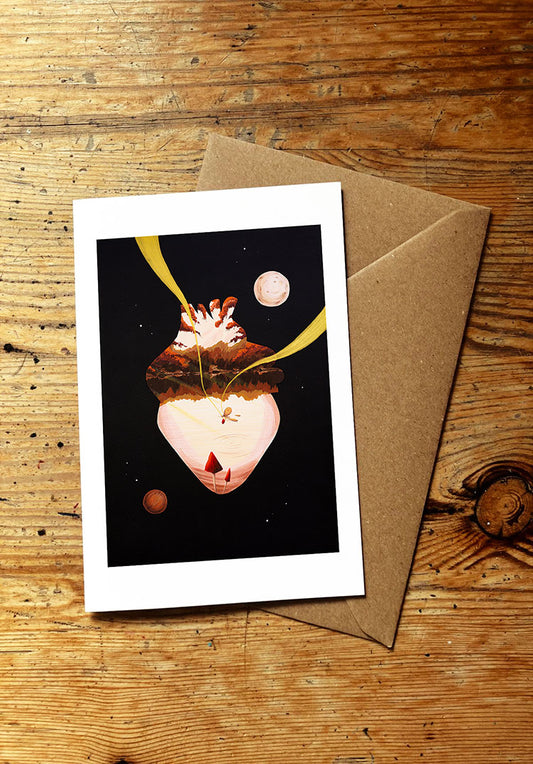 Greeting card with a wild swimming and space-themed design on a wooden surface with a brown envelope.
